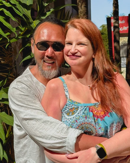 Happy couple smiling together, showcasing the male patient's natural-looking dental implant results.