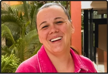 A close-up portrait of a woman with a wide, confident smile, representing the joy and natural appearance achieved with full mouth dental implants.