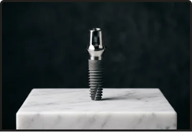 A close-up view of a single titanium dental implant post and abutment standing on a grey marble base against a dark background, representing a durable and common implant option.