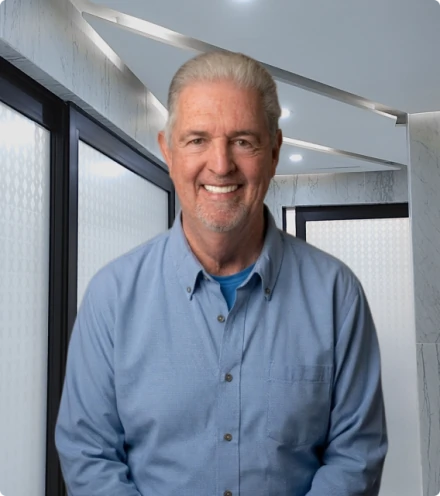 Smiling senior man in a modern dental office representing successful dental implant results.