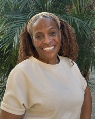Portrait of a confident, smiling senior woman showcasing her new smile results in a tropical setting.