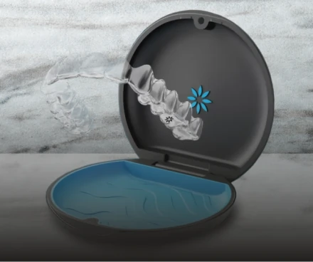 A set of invisible Clear Aligners resting inside their open protective case.