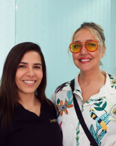 patient showcasing her new perfect smile alongside dental specialist