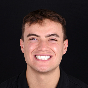 Young man with short brown hair, beaming a complete dental makeover in cancun mexico